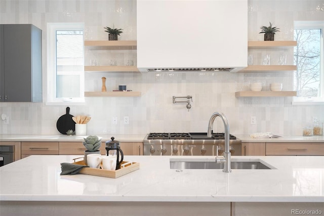 kitchen with backsplash, a healthy amount of sunlight, and light stone countertops