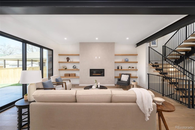 living room featuring a large fireplace and light hardwood / wood-style flooring