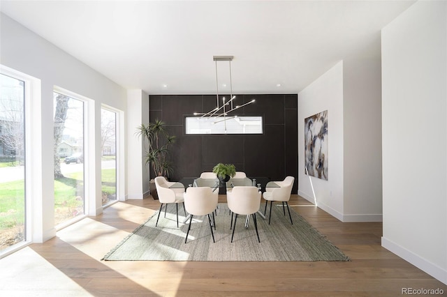 dining room featuring a wealth of natural light, light hardwood / wood-style floors, and a notable chandelier