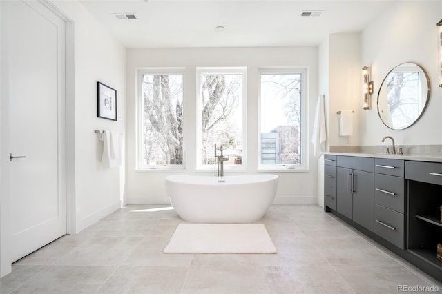 bathroom featuring tile flooring, a healthy amount of sunlight, and vanity