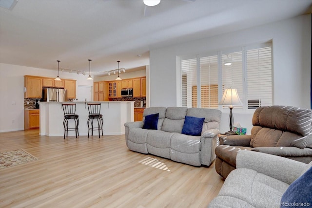 living room with visible vents, ceiling fan, and light wood-style flooring