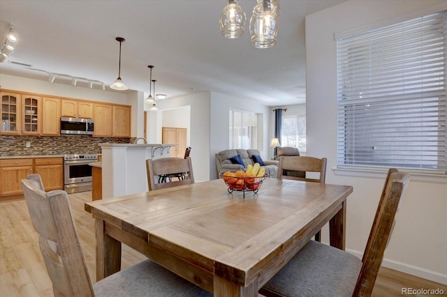 dining area featuring baseboards, visible vents, and light wood finished floors