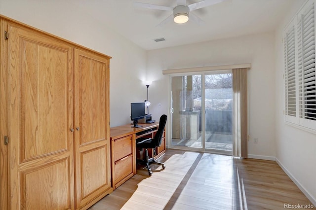 office space with light wood finished floors, a ceiling fan, visible vents, and baseboards