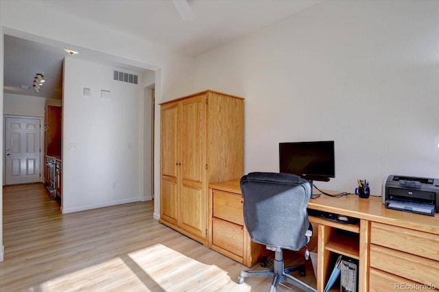 office space with light wood-style flooring, visible vents, and baseboards