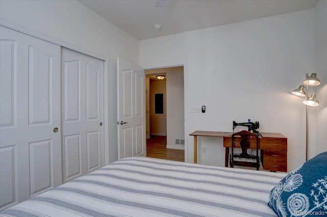 bedroom with a closet, visible vents, and wood finished floors