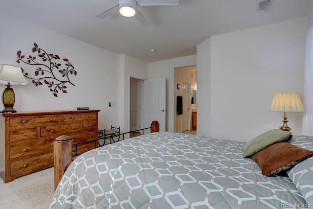 carpeted bedroom featuring ceiling fan, visible vents, and ensuite bathroom