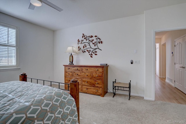 carpeted bedroom with a ceiling fan, visible vents, and baseboards