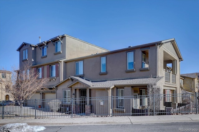 multi unit property with concrete driveway, fence, an attached garage, and stucco siding