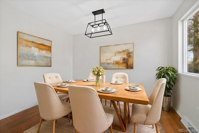 dining room with a healthy amount of sunlight, visible vents, and wood finished floors