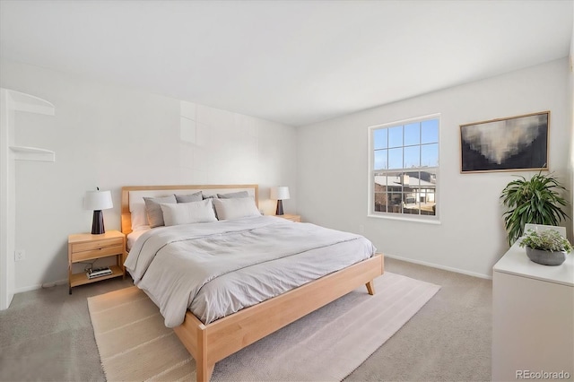 bedroom with light carpet and baseboards