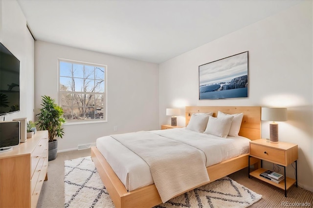 bedroom featuring baseboards, visible vents, and light colored carpet