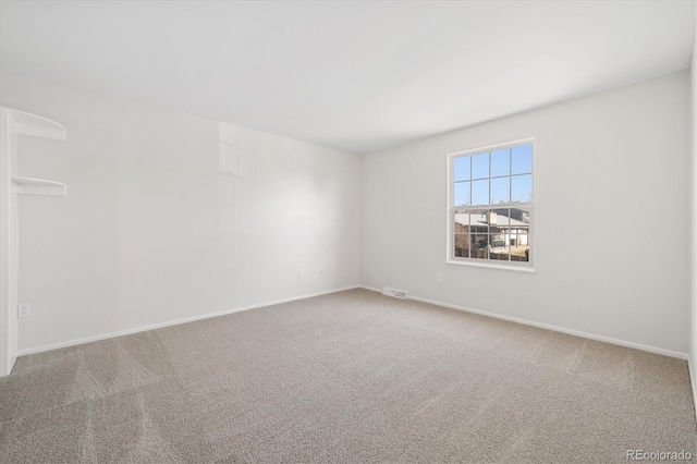 carpeted empty room with visible vents and baseboards