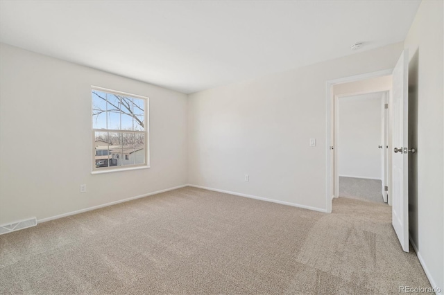 empty room featuring baseboards, visible vents, and carpet flooring