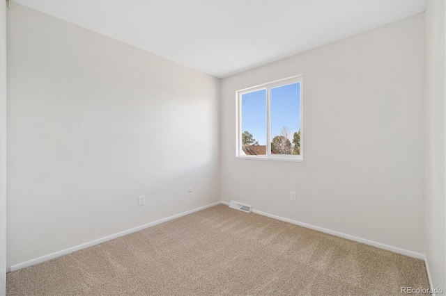 carpeted empty room with visible vents and baseboards