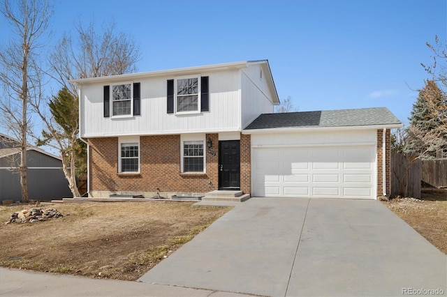 colonial-style house featuring a garage, brick siding, driveway, and fence