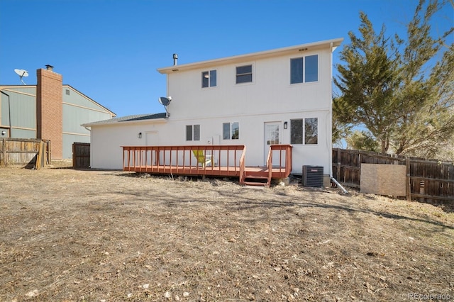 back of property with fence, a deck, and cooling unit