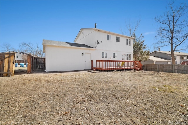 rear view of house with a fenced backyard and a wooden deck