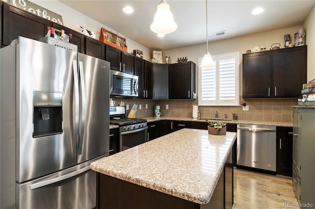1640 Aspen Meadows Cir, Federal Heights, CO 80260 - kitchen with stainless steel appliances, backsplash, hanging light fixtures, light wood-style flooring, and dark brown cabinetry