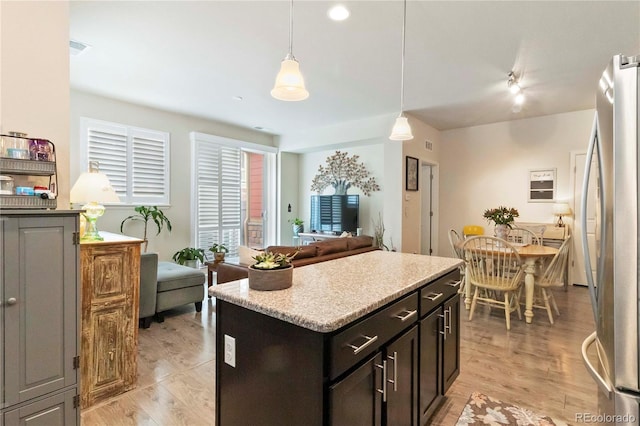 1640 Aspen Meadows Cir, Federal Heights, CO 80260 - kitchen with freestanding refrigerator, decorative light fixtures, a kitchen island, open floor plan, and light wood-style flooring
