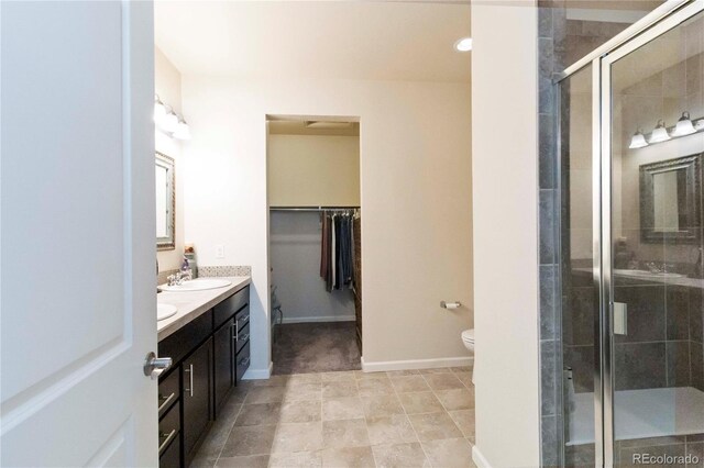 1640 Aspen Meadows Cir, Federal Heights, CO 80260 - full bath featuring double vanity, a walk in closet, a stall shower, toilet, and baseboards