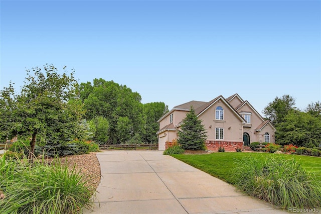 7355 Nile St, Arvada, CO 80007 - view of front of home with stucco siding, driveway, and a front lawn