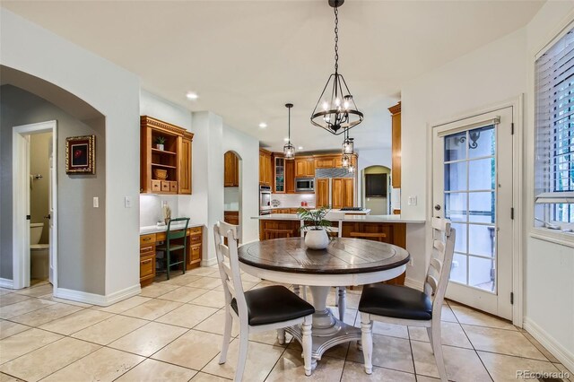 7355 Nile St, Arvada, CO 80007 - dining room with a chandelier, light tile patterned floors, arched walkways, and recessed lighting