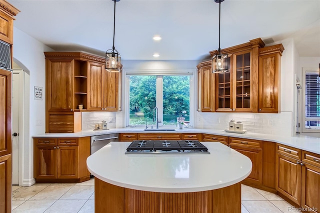 7355 Nile St, Arvada, CO 80007 - kitchen with brown cabinetry, a center island, light countertops, light tile patterned floors, and recessed lighting