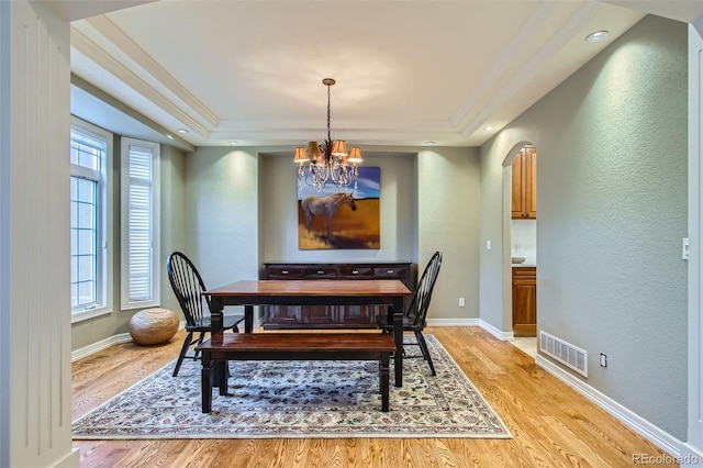 7355 Nile St, Arvada, CO 80007 - dining area with a chandelier, light wood finished floors, a textured wall, healthy amount of natural light, and crown molding
