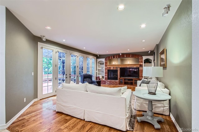 7355 Nile St, Arvada, CO 80007 - living area featuring a fireplace, wood finished floors, french doors, and recessed lighting