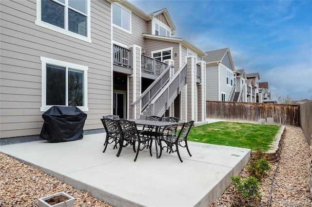view of patio / terrace featuring a residential view, stairs, outdoor dining space, and grilling area