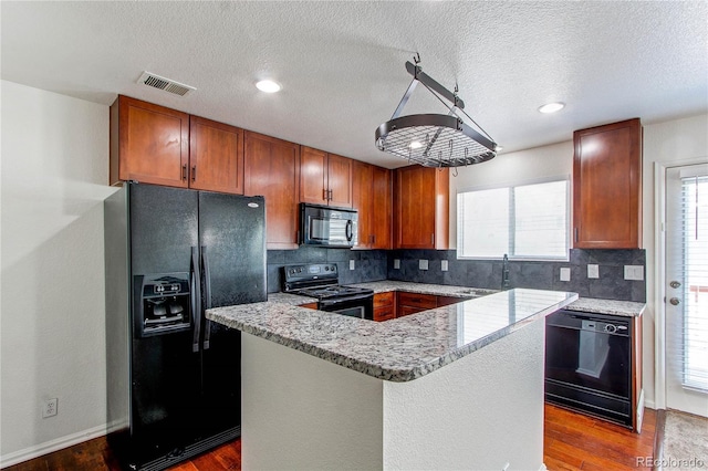 19043 E 58th Ave, Denver, CO 80249 - kitchen with black appliances, decorative backsplash, dark wood-style floors, brown cabinetry, and a textured ceiling