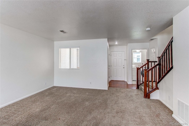 19043 E 58th Ave, Denver, CO 80249 - empty room with carpet, a textured ceiling, stairs, and a smoke detector