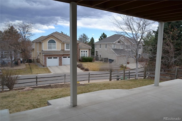 exterior space with driveway, a fenced front yard, and an attached garage