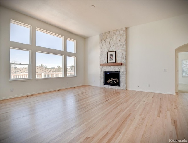 unfurnished living room featuring light wood-style floors, a fireplace, and baseboards