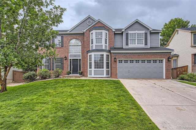9458 S Hackberry Ln, Highlands Ranch, CO 80129 - view of front of house with brick siding, driveway, and a garage