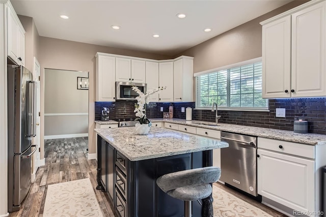 9458 S Hackberry Ln, Highlands Ranch, CO 80129 - kitchen with stainless steel appliances, a sink, white cabinets, decorative backsplash, and recessed lighting