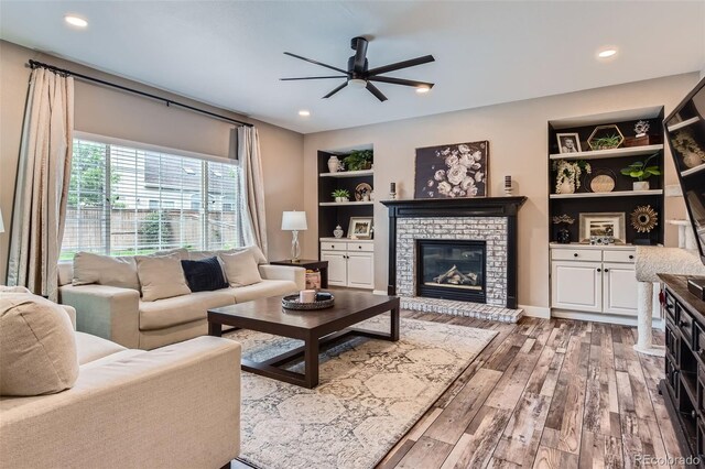 9458 S Hackberry Ln, Highlands Ranch, CO 80129 - living room featuring a ceiling fan, wood-type flooring, a fireplace, built in shelves, and recessed lighting