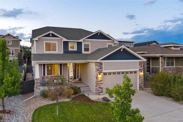 craftsman-style home with roof with shingles, concrete driveway, a front yard, fence, and a garage