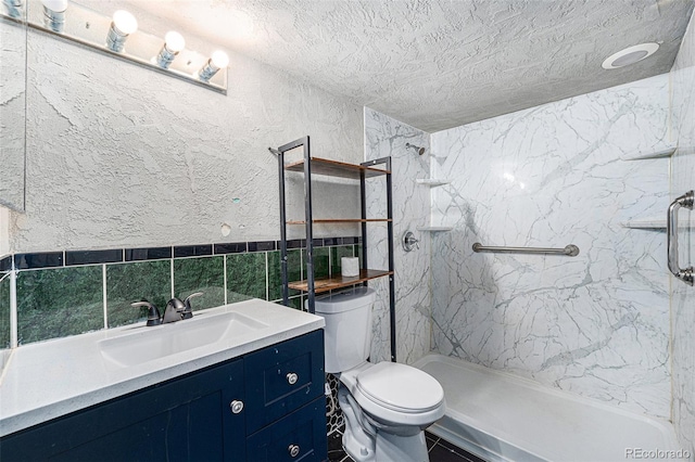 9712 Adams St, Thornton, CO 80229 - full bath with a marble finish shower, toilet, a textured ceiling, vanity, and tile walls