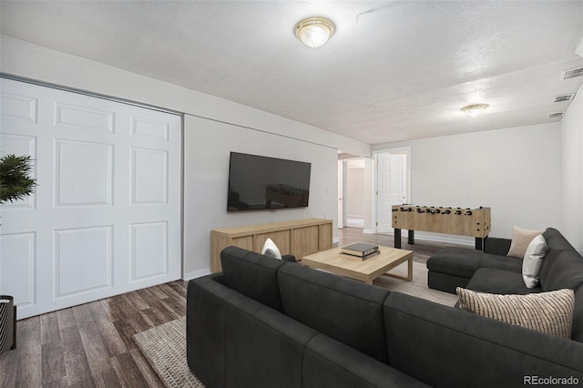 9712 Adams St, Thornton, CO 80229 - living area featuring dark wood-type flooring, baseboards, and a textured ceiling