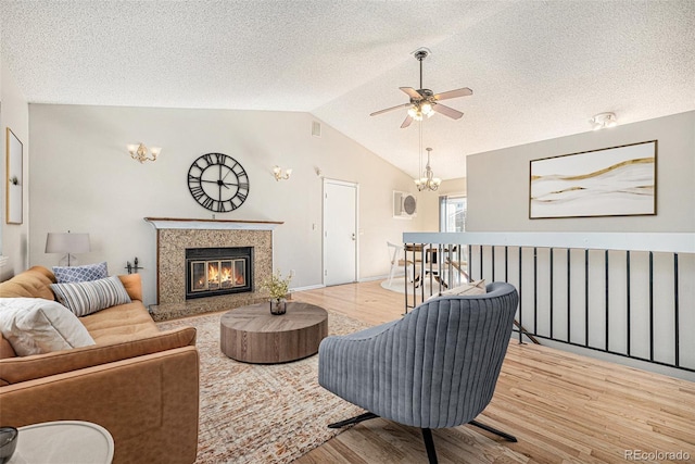 9712 Adams St, Thornton, CO 80229 - living room featuring wood finished floors, ceiling fan, lofted ceiling, a glass covered fireplace, and a textured ceiling