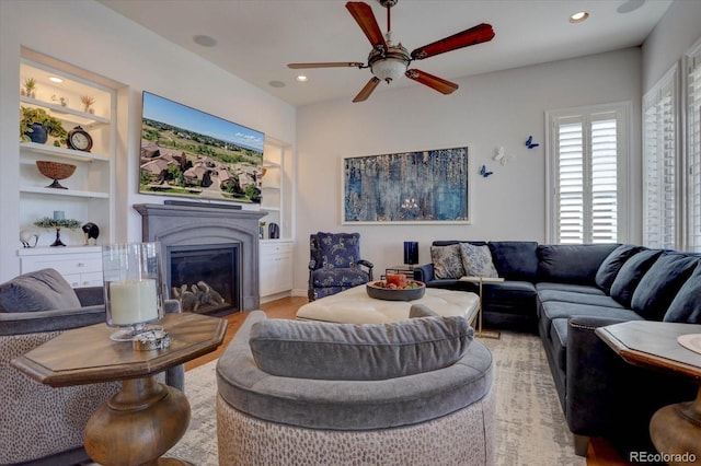 living room with light hardwood / wood-style flooring, built in features, and ceiling fan