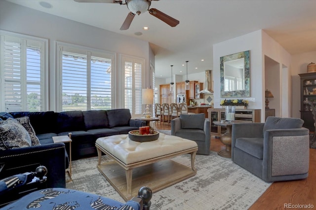 living room featuring ceiling fan and light hardwood / wood-style floors