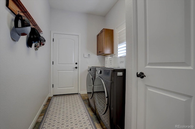 clothes washing area with washer and clothes dryer, cabinets, and light tile patterned floors