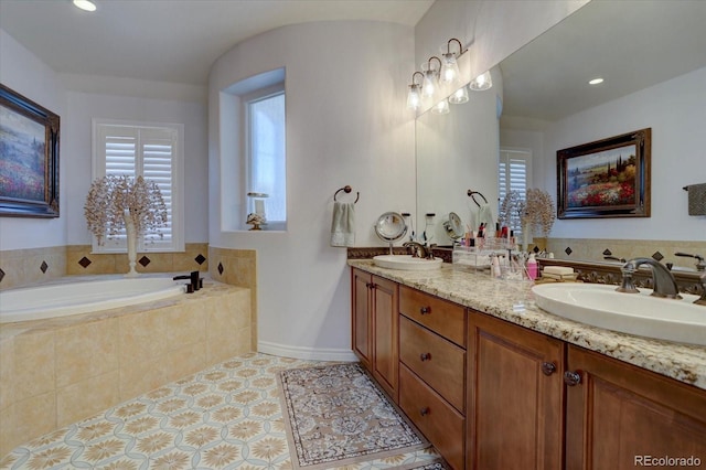 bathroom with tiled bath and vanity