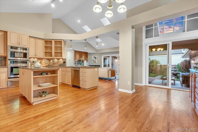 kitchen with high vaulted ceiling, stainless steel appliances, light hardwood / wood-style flooring, and decorative backsplash