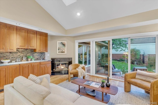 living room with light wood-type flooring and high vaulted ceiling