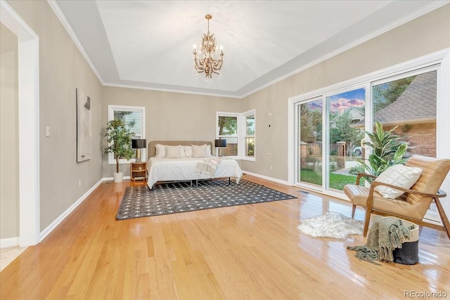 unfurnished bedroom with access to outside, a notable chandelier, light hardwood / wood-style flooring, and ornamental molding