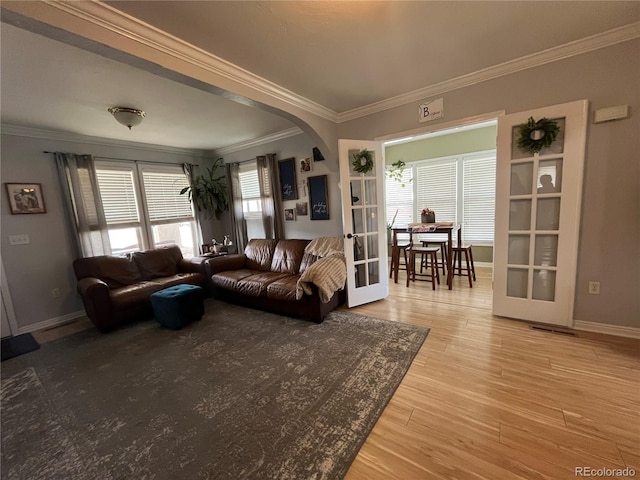 790 4th St, Limon, CO 80828 - living room with crown molding, arched walkways, french doors, light wood-style flooring, and baseboards