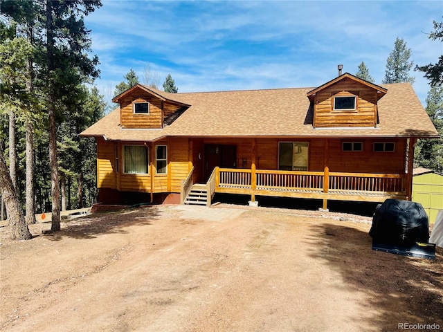 log cabin featuring roof with shingles and a porch